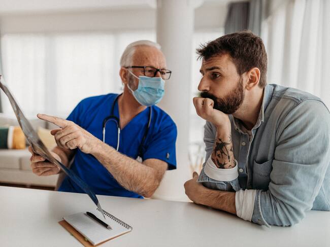 Hombre escuchando a profesional de la salud (Getty Images)