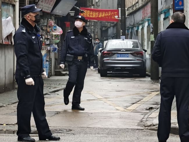 Policía china recorriendo las calles de Wuhan. 