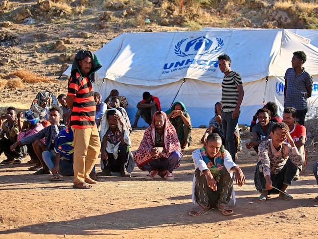 Refugiados etíopes afuera de una carpa de la ACNUR ubicada en un campo de refugiados al este de Sudán.