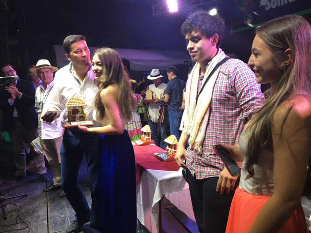 El representante a la cámara  Hernán Penagos entrega el premio al dueto Cantares