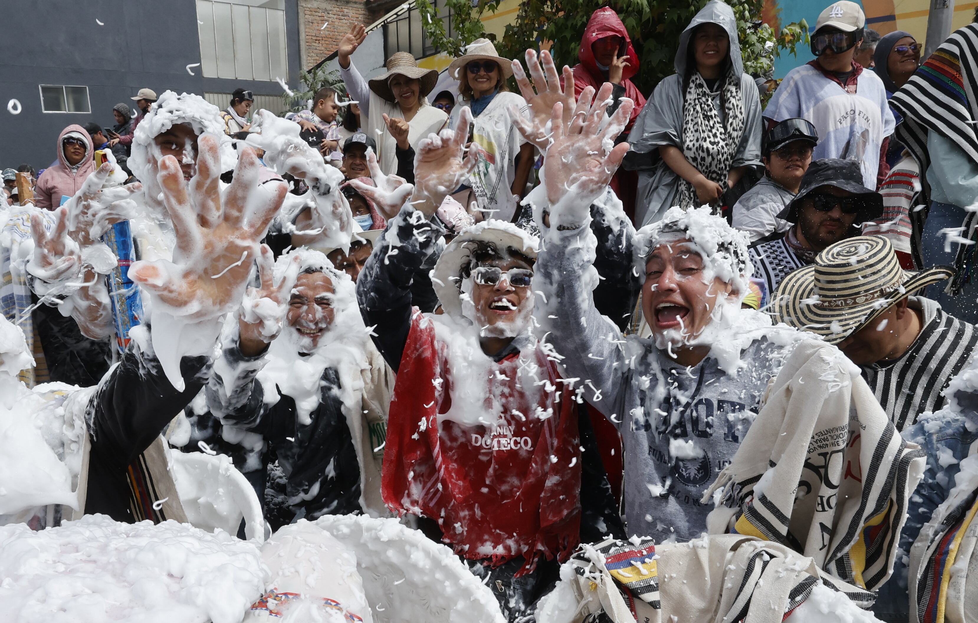 AME9033. PASTO (COLOMBIA), 06/01/2025.- Asistentes se divierten con espuma durante el Desfile Magno en el marco del Carnaval de Negros y Blancos, este lunes en Pasto (Colombia). El Desfile Magno de carrozas se tomó las principales calles en el cierre del Carnaval de Negros y Blancos, proclamado por la Unesco en 2009 como Obra Maestra del Patrimonio Cultural Inmaterial de la Humanidad. EFE/ Mauricio Dueñas Castañeda