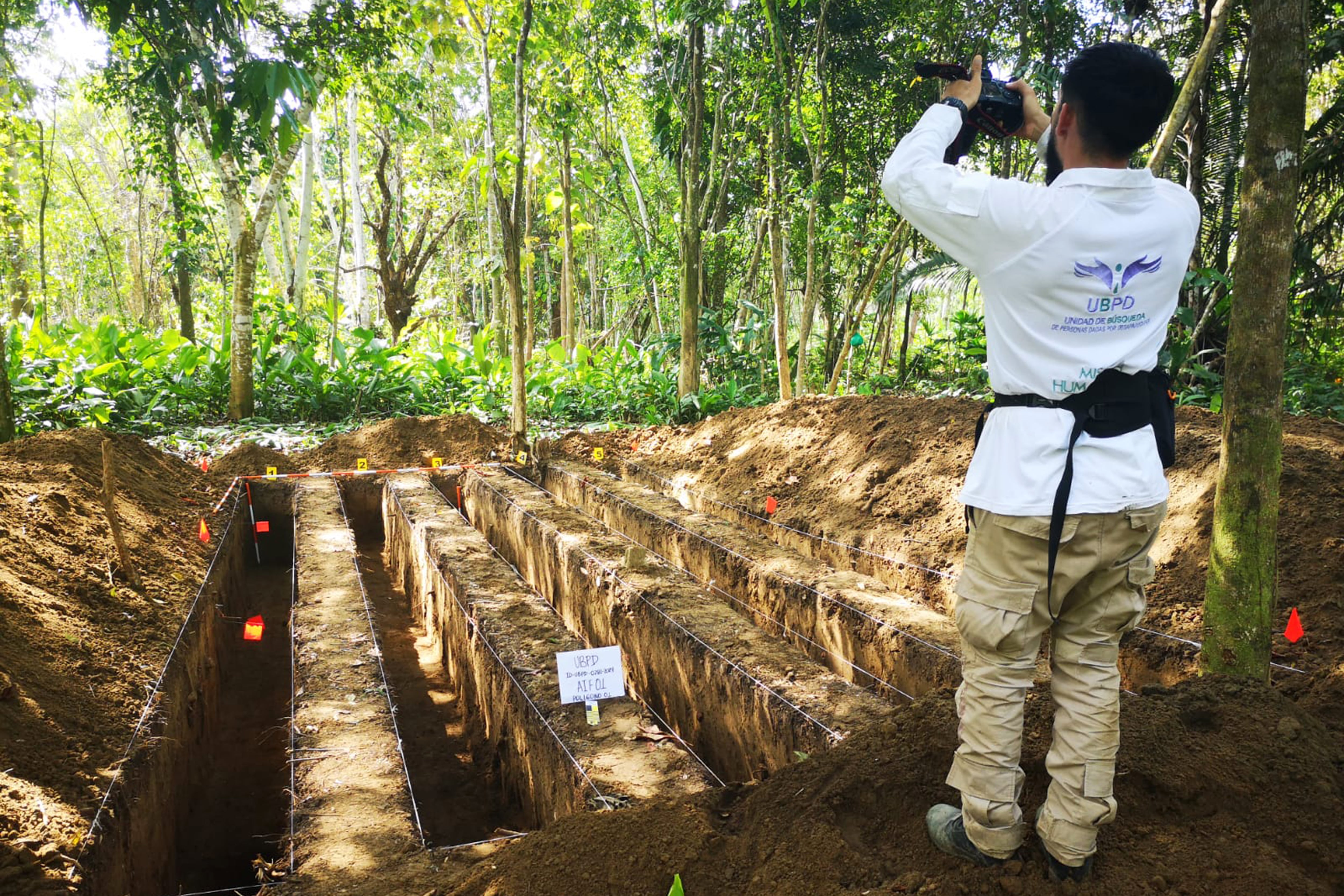 RIO400 RIOSUCIO (COLOMBIA), 26/03/2024.- Fotografía cedida por la Unidad de Búsqueda de Personas dadas por Desaparecidas (UBPD) que muestra a un investigador mientras toma una foto de la excavación realizada en la recuperación de restos mortales de diez desaparecidos en zona rural de Riosucio, departamento de Chocó (Colombia). La Unidad de Búsqueda de Personas dadas por Desaparecidas (UBPD) recuperó los cuerpos de diez víctimas del conflicto armado, de los cuales, al parecer, nueve corresponden a desaparecidos por una incursión armada en el selvático departamento del Chocó (oeste) en 1999. EFE/Unidad de Búsqueda de Personas dadas por Desaparecidas / SÓLO USO EDITORIAL/SÓLO DISPONIBLE PARA ILUSTRAR LA NOTICIA QUE ACOMPAÑA (CRÉDITO OBLIGATORIO)