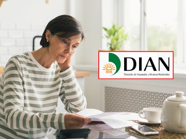 Mujer revisando sus cuentas y deudas con preocupación en su casa (Getty Images) / DIAN