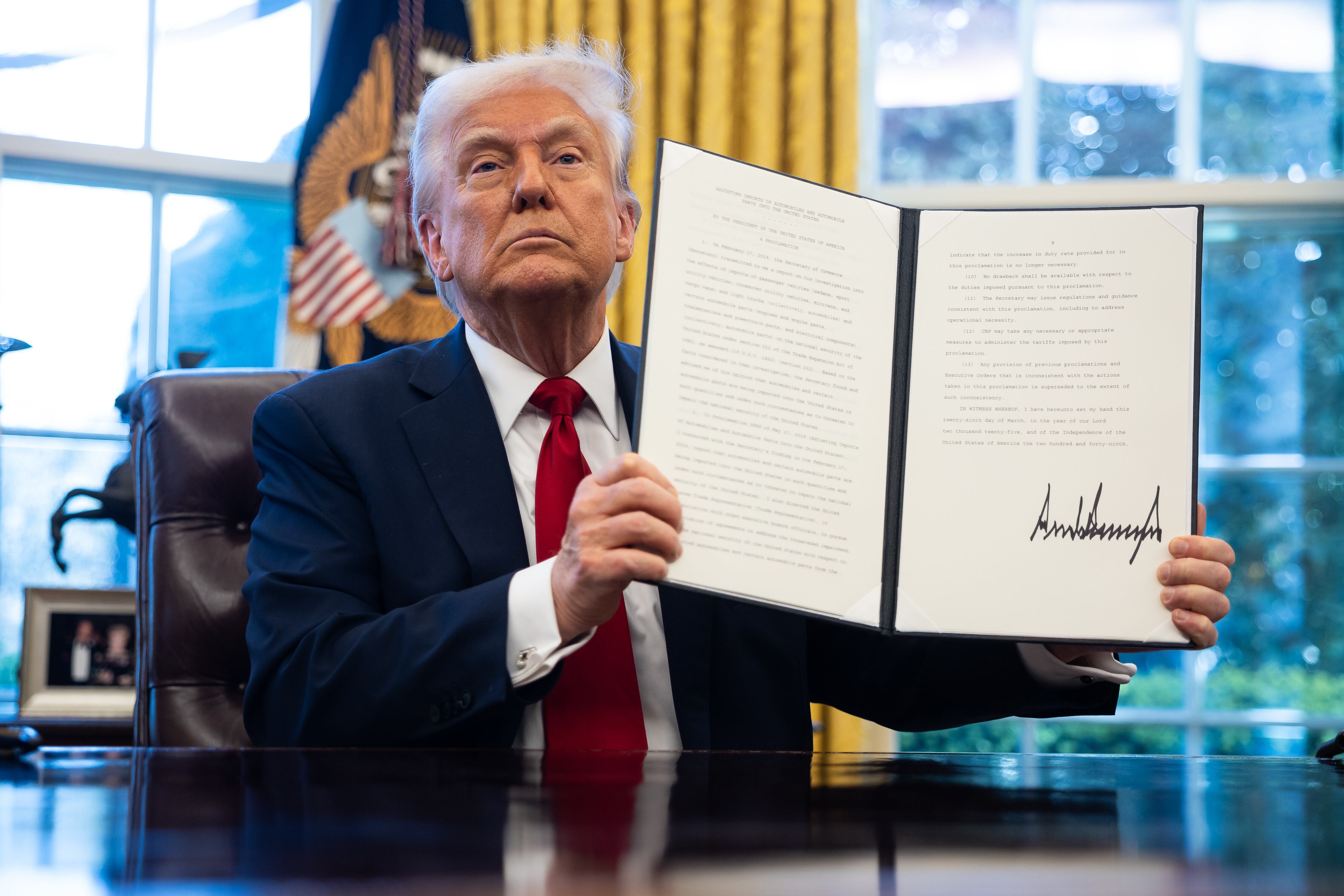 WASHINGTON (United States), 26/03/2025.- US President Donald Trump holds up an executive order on auto tariffs after signing it in the Oval Office at the White House in Washington, DC, USA, 26 March 2025. EFE/EPA/FRANCIS CHUNG / POOL