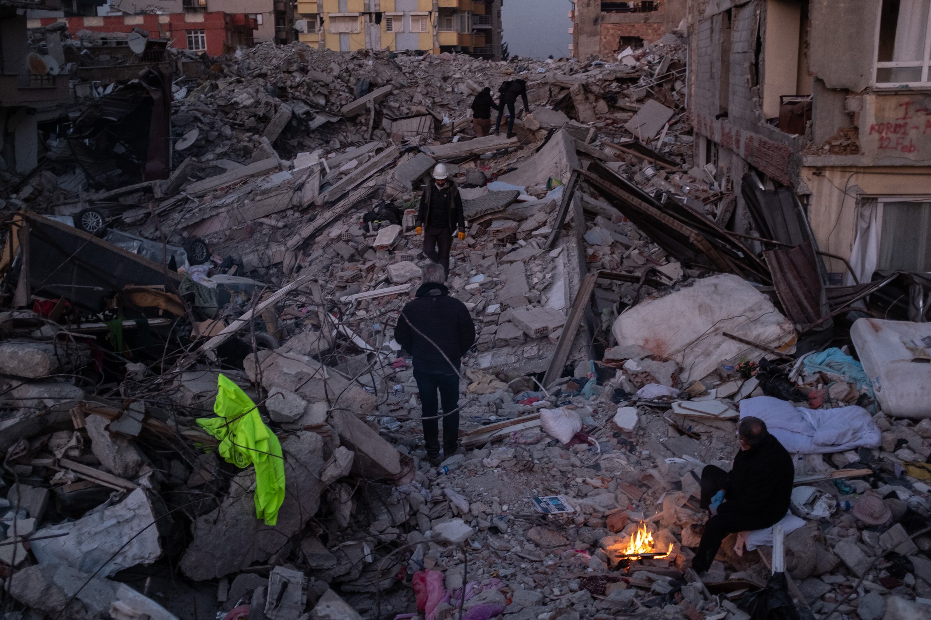 La gente pasa junto a montones de escombros el 15 de febrero de 2023 en Hatay, Turquía. Foto de Burak Kara/Getty Images.