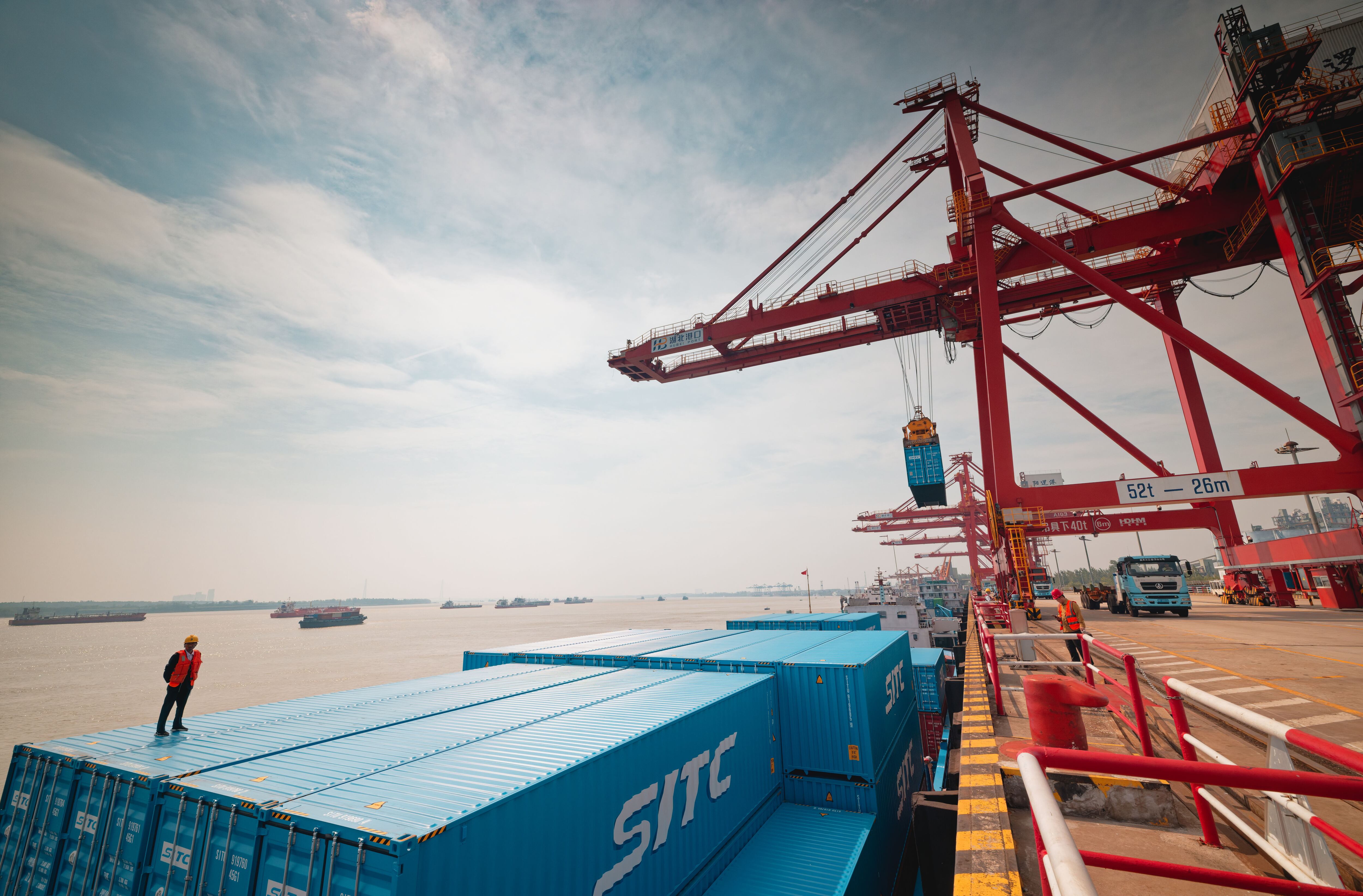 Wuhan (China), 23/05/2025.- A worker prepares containers from a cargo ship for offloading to trucks at Yangluo Port during an organized press trip in Wuhan, Hubei province, China, 23 May 2025. Yangluo Port, located on the north bank of the Yangtze River in eastern Wuhan, is a key deep-water port with depths ranging from 7 to 15 meters. It is the largest container hub along the middle and upper reaches of the Yangtze River, serving as a vital 'gateway to the sea' for central and western China. EFE/EPA/ALEX PLAVEVSKI