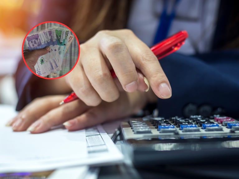 Persona haciendo cuentas de sus recibos y al lado dinero colombiano (Fotos vía Getty Images)