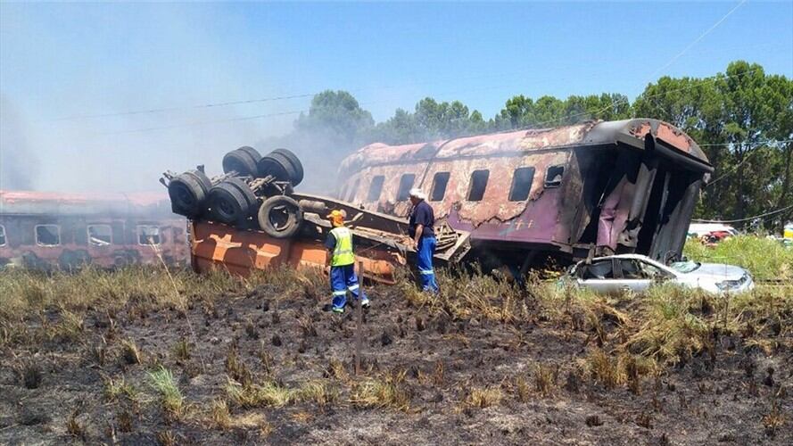 Varios miembros de los servicios de rescate inspeccionan los restos de un tren intercity que descarriló tras chocar con un camión que cruzaba las vías en Kroonstad (Sudáfrica). Foto: Agencia EFE/ER24EMS