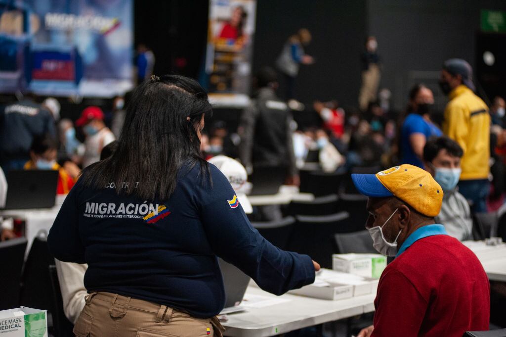 Officers of Colombia's migration office 'Migracion Colombia' help venezuelan migrants in the process of documentation on January 27, 2022.