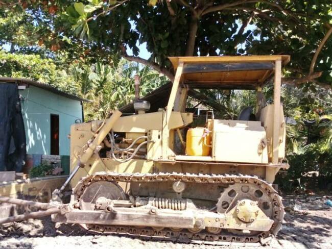 Rellenaban terreno de baja mar, en La Boquilla, empleando un bulldozer