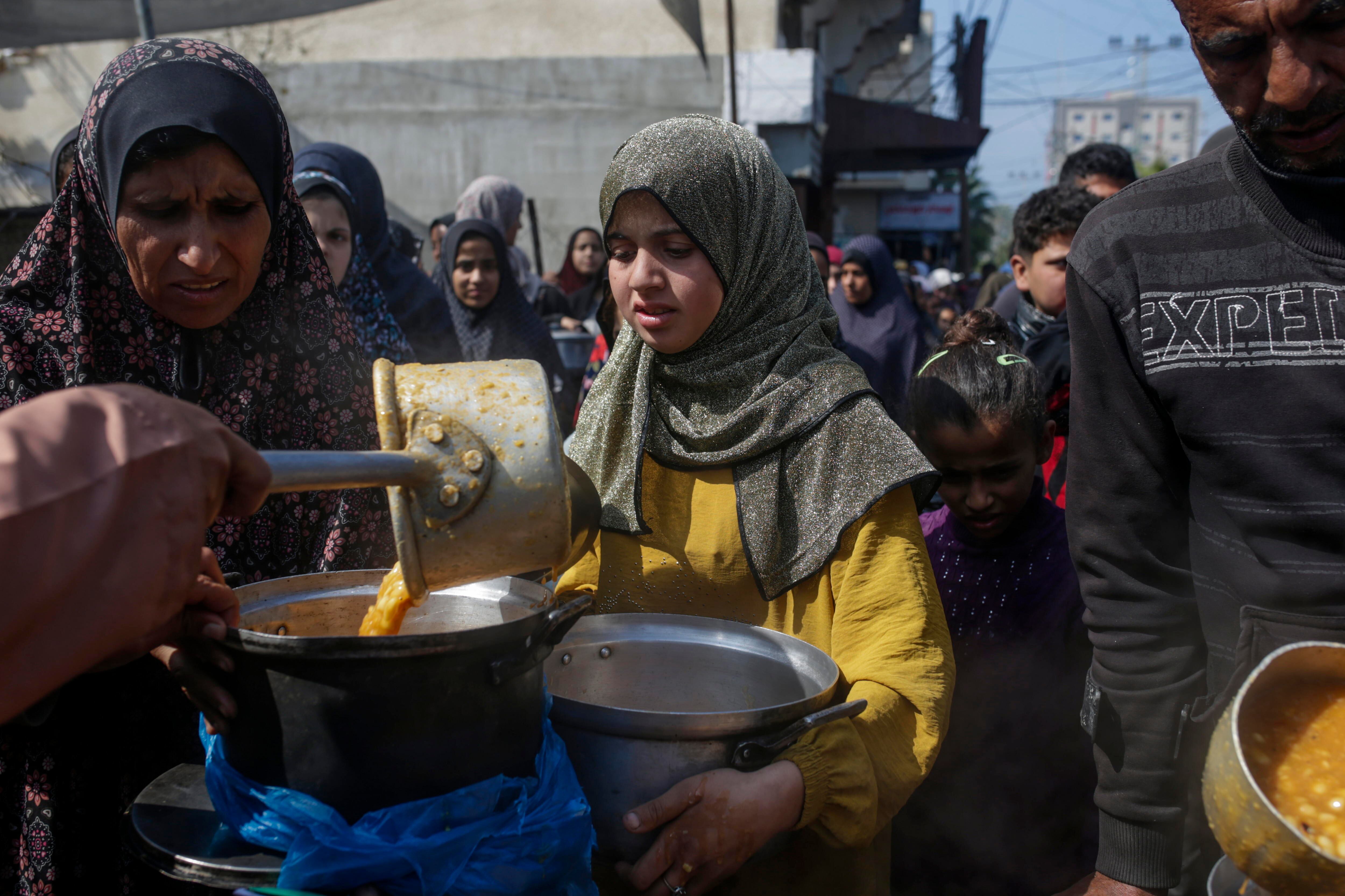 Deir Al Balah (-), 24/02/2024.- Internally displaced Palestinians receive food provided by Arab and Palestinian donors in Deir Al Balah town, southern Gaza Strip, 24 February 2024. Since 07 October, up to 1.9 million people, or more than 85 percent of the population, have been displaced throughout the Gaza Strip, some more than once, according to the United Nations Relief and Works Agency for Palestine Refugees in the Near East (UNRWA), which added that most civilians in Gaza are in 'desperate need of humanitarian assistance'. EFE/EPA/MOHAMMED SABER