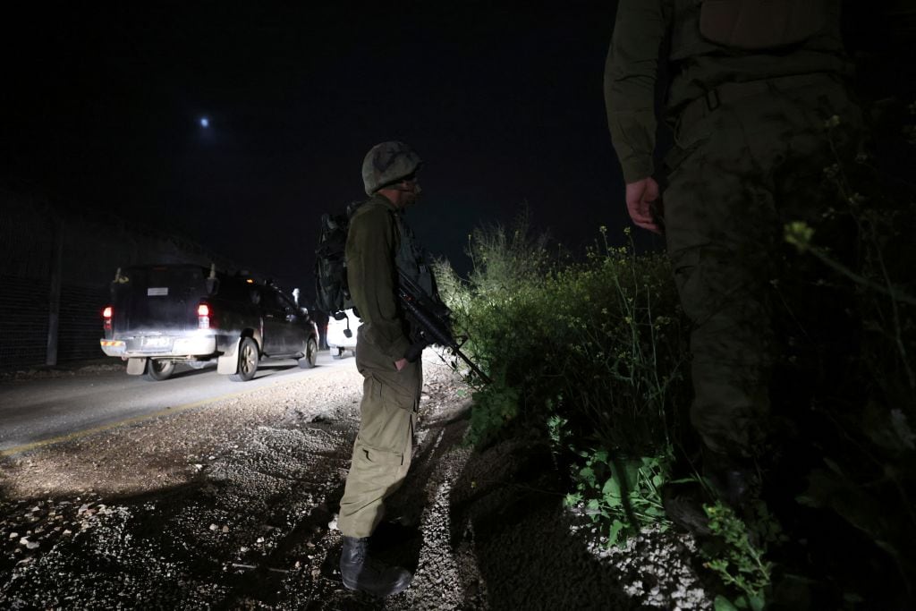 Israeli soldiers search for a rocket that landed near Kibbutz Meitsar in the Israeli annexed Golan Heights, April 9, 2023. - Three rockets were fired Saturday night, April 8, 2023, from Syria towards Israel, the Israeli army said, following earlier rocket fire from Lebanon which the army blamed on Palestinian militants."One of the rockets crossed into Israeli territory and landed in open areas in the southern Golan Heights" which are occupied by Israel, the army said. (Photo by JALAA MAREY / AFP) (Photo by JALAA MAREY/AFP via Getty Images)