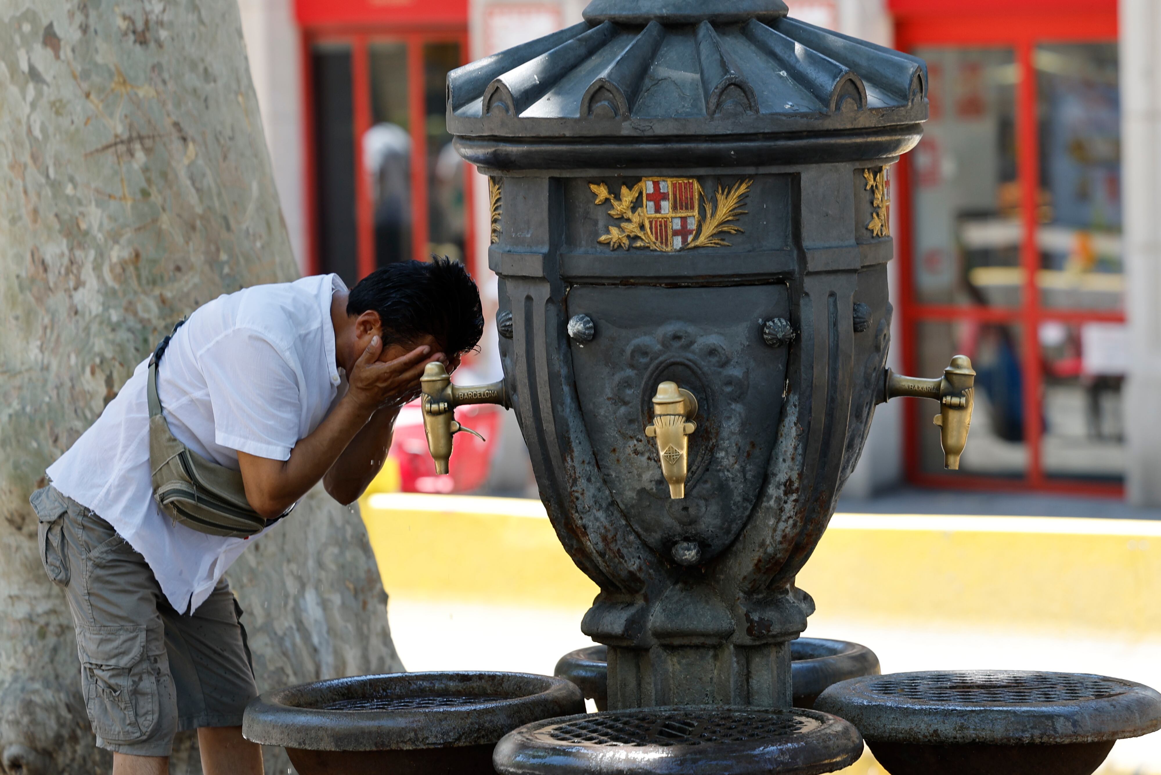 BARCELONA, 28/06/2025.- Un turista se refresca en una fuente en Barcelona este sábado. Catorce comunidades están este sábado en alerta por temperaturas excepcionalmente altas en el día de inicio de la primera ola de calor del verano en España. EFE/ Toni Albir