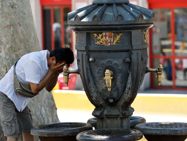 BARCELONA, 28/06/2025.- Un turista se refresca en una fuente en Barcelona este sábado. Catorce comunidades están este sábado en alerta por temperaturas excepcionalmente altas en el día de inicio de la primera ola de calor del verano en España. EFE/ Toni Albir