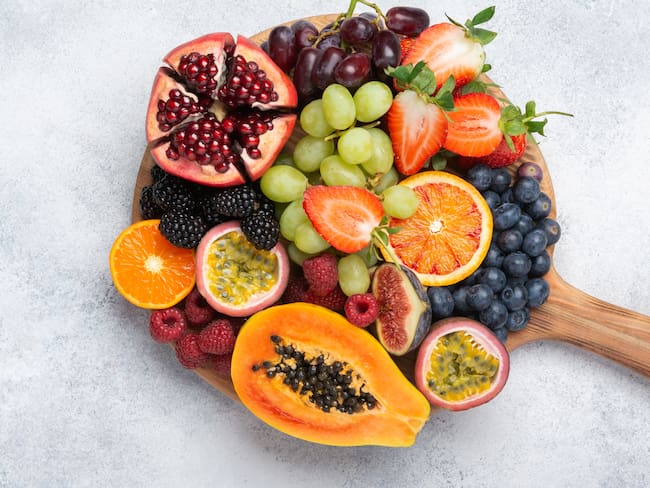 Diferentes tipos de fruta en una superficie redonda de madera (Foto vía Getty Images)