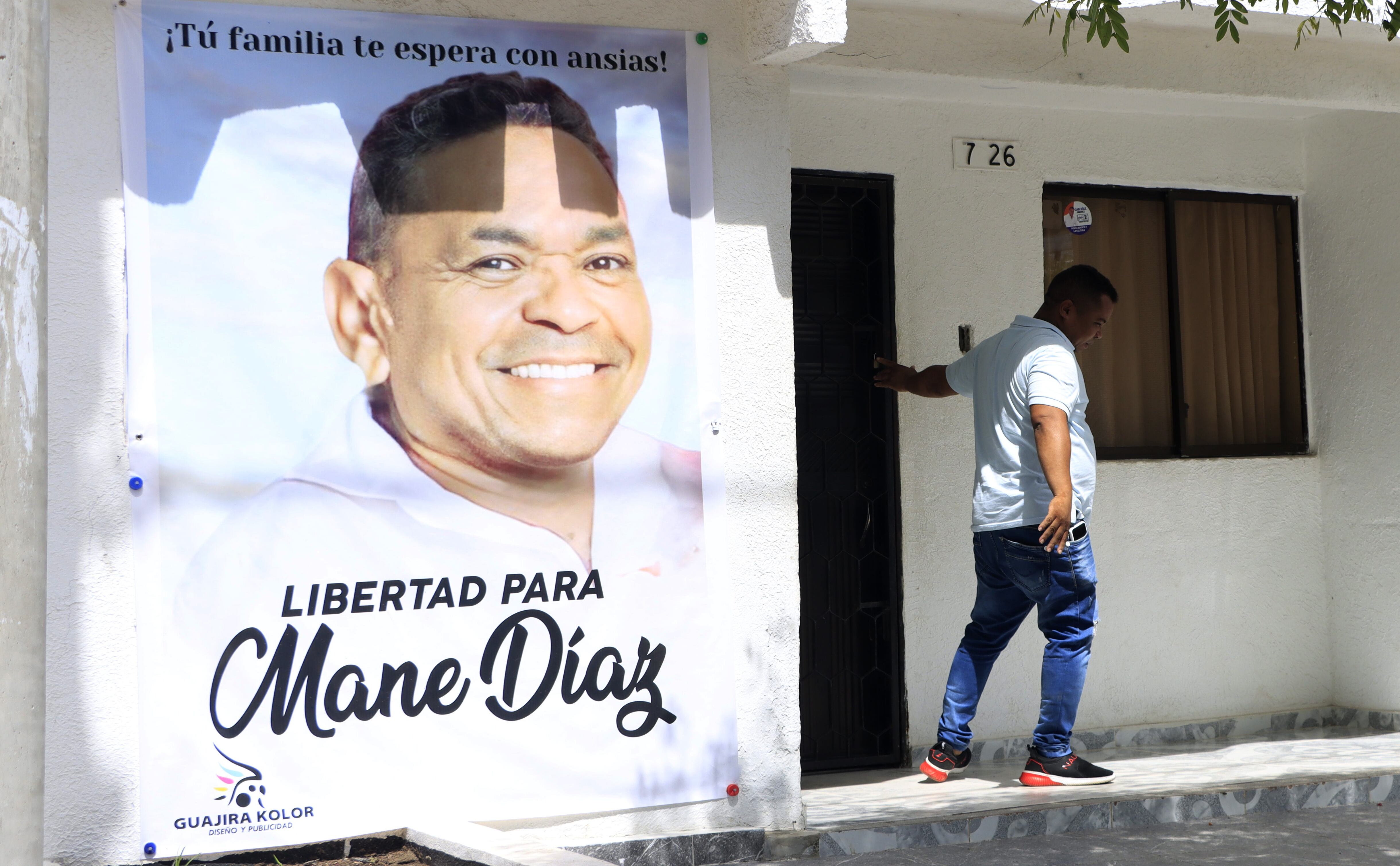 AME3879. BARRANCAS (COLOMBIA), 03/11/2023.- Una persona sale hoy de la casa familiar del futbolista colombiano Luis Díaz, de donde cuelga un gran cartel con la imagen de su padre, Luis Manuel Díaz, secuestrado el pasado sábado, en Barrancas, departamento de La Guajira (Colombia). En este pueblo minero del norte de Colombia donde nació el delantero Luis Díaz, del club inglés Liverpool y de la selección nacional, sus 35.000 habitantes esperan la liberación cuanto antes de su padre. Tras la revelación ayer de que el secuestro fue perpetrado por el Ejército de Liberación Nacional (ELN), aumentó la esperanza de que pronto regrese a su libertad, justamente por estar ese grupo armado en una negociación de paz con el Gobierno. EFE/ Ricardo Maldonado Rozo