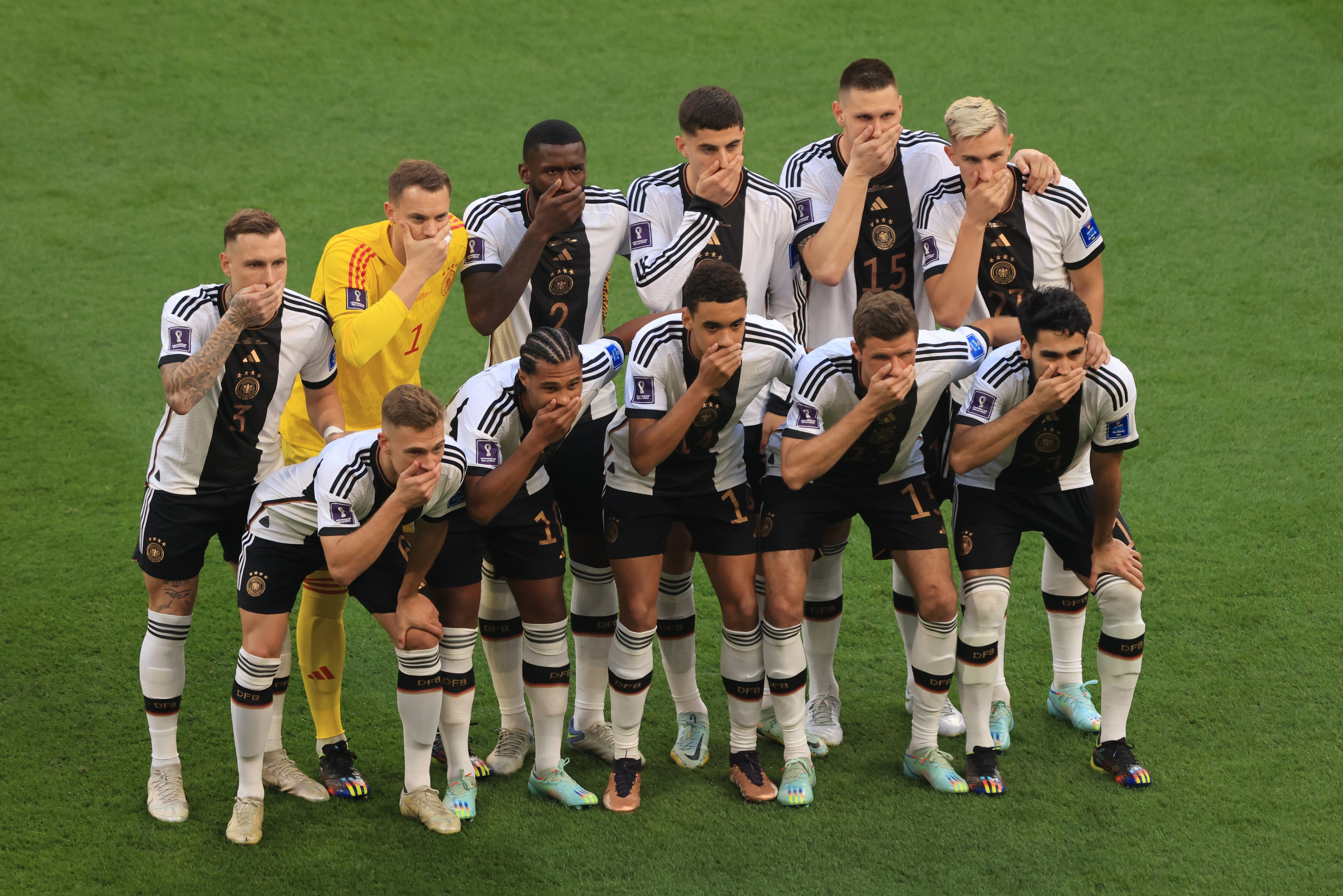 DOHA, QATAR - NOVEMBER 23:  Germany players cover their mouths as they pose for a team photo during the FIFA World Cup Qatar 2022 Group E match between Germany and Japan at Khalifa International Stadium on November 23, 2022 in Doha, Qatar. (Photo by Marc Atkins/Getty Images)
