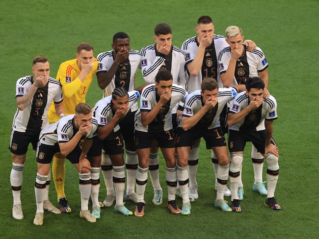 DOHA, QATAR - NOVEMBER 23:  Germany players cover their mouths as they pose for a team photo during the FIFA World Cup Qatar 2022 Group E match between Germany and Japan at Khalifa International Stadium on November 23, 2022 in Doha, Qatar. (Photo by Marc Atkins/Getty Images)