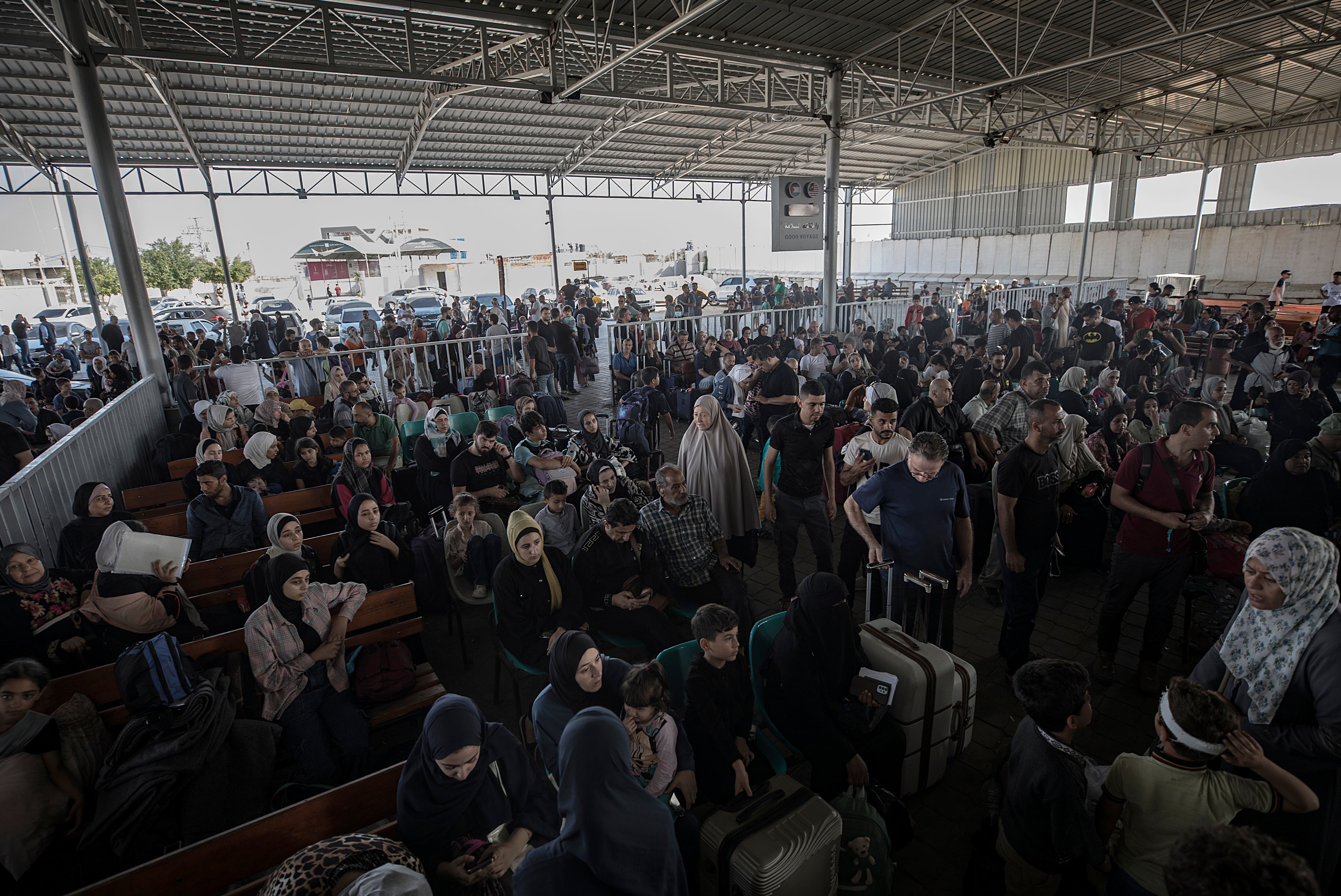 -FOTODELDÍA- EA3850. GAZA (GAZA Y CISJORDANIA), 01/11/2023.- Cientos de ciudadanos palestinos esperan para cruzar a Egipto este miércoles, en el cruce fronterizo de Rafah entre la Franja de Gaza y Egipto. El 1 de noviembre, ambulancias que transportaban a evacuados de la Franja de Gaza atravesaron el cruce fronterizo de Rafah. Según el acuerdo firmado entre Egipto, Israel y Hamás, a varios ciudadanos extranjeros y personas con heridas graves se les permitirá evacuar el territorio asediado. Más de 8.500 palestinos y al menos 1.400 israelíes han muerto, según las Fuerzas de Defensa de Israel (FDI) y la autoridad sanitaria palestina, desde que militantes de Hamás lanzaron un ataque contra Israel desde la Franja de Gaza el 7 de octubre, y las operaciones israelíes en Gaza y Cisjordania, que le siguió. EFE/ Haitham Imad