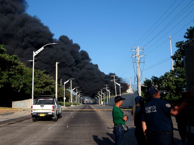 AME2203. BARRANQUILLA (COLOMBIA), 21/12/2022.- Fotografía de una nube de humo negro provocada por incendio en un depósito de combustible en la zona industrial de Barranquilla (Colombia). Un incendio de grandes proporciones se produjo en la madrugada de este miércoles en la zona industrial de la ciudad colombiana de Barranquilla, que ha provocado la muerte de un bombero durante las labores de extinción y que se hayan paralizado todas las operaciones portuarias. EFE/ Oscar Berrocal