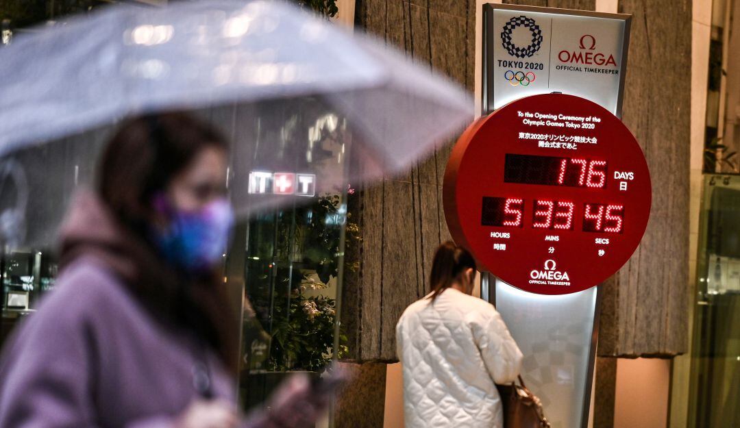 Japoneses junto al reloj de cuenta regresiva para los Juegos Olímpicos en Tokyo.