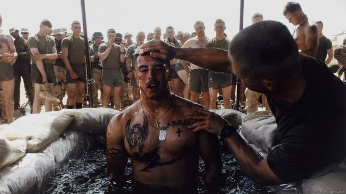 "Por la forma como está organizada -dice Michels- la exhibición le permite al observador ponerse en los zapatos del soldado o del fotógrafo, tener una experiencia que sea lo más cercana posible a como es en la realidad: el adoctrinamiento, el campo de batalla, la muerte en el frente". En esta foto, el cabo Albert Martínez es bautizado durante una ceremonia en Kuwait, en 2003.