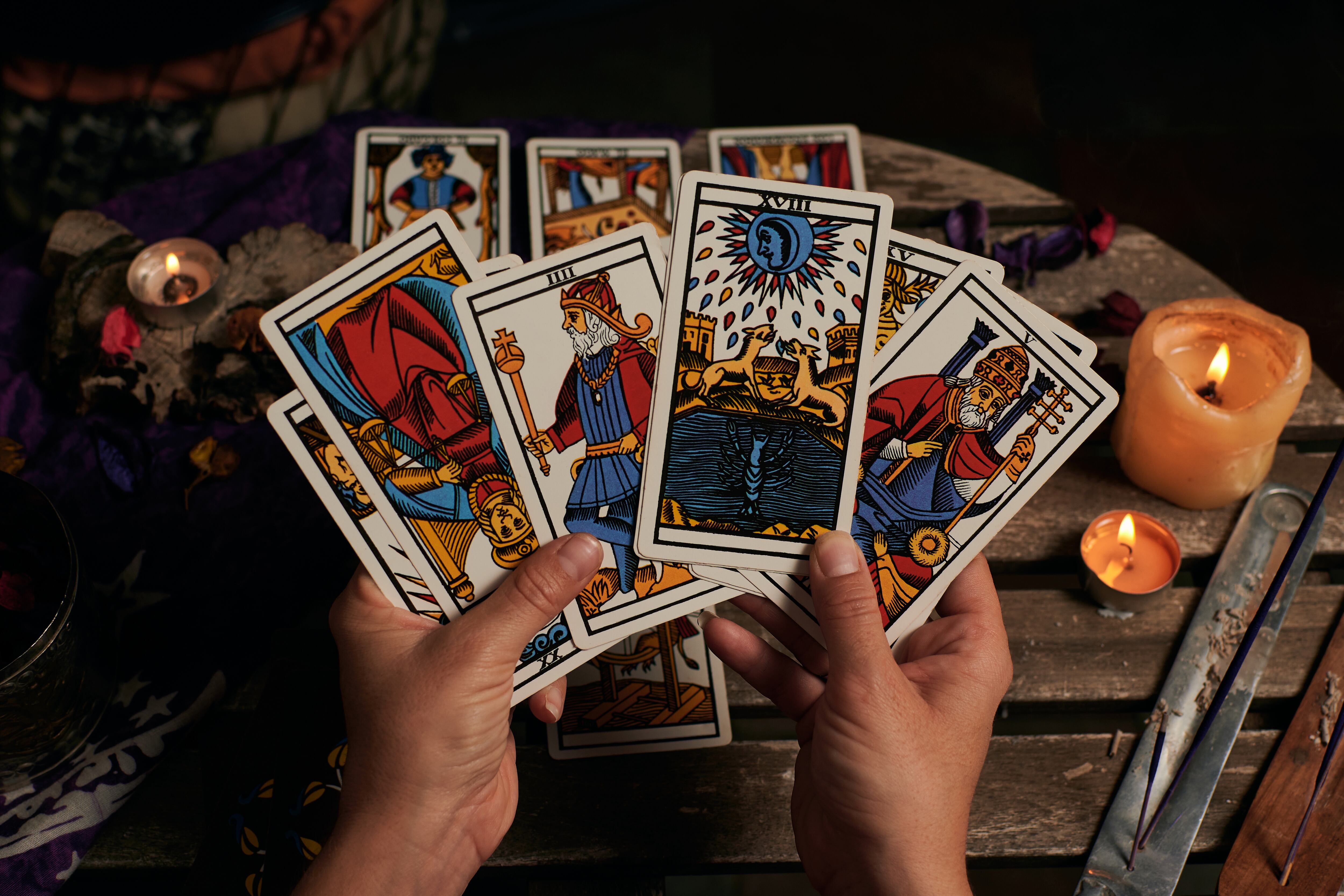 Persona sosteniendo varias cartas del tarot (Foto vía Getty Images)