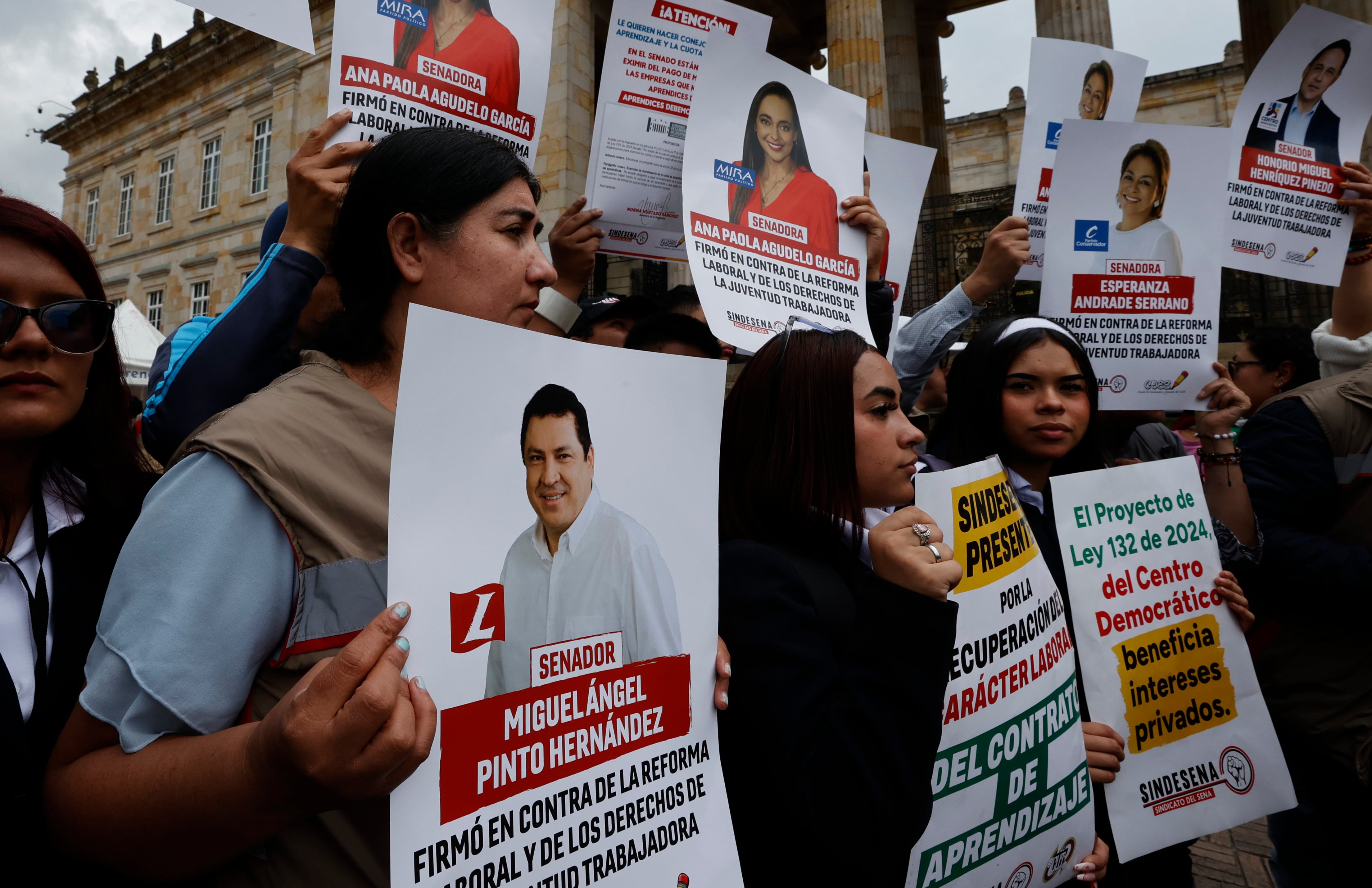 AME8809. BOGOTÁ (COLOMBIA), 12/03/2025.- Estudiantes del Servicio Nacional de Aprendizaje (SENA) protestan frente al Congreso de la República sosteniendo las fotografías de los senadores que archivaron la reforma laboral este miércoles, en Bogotá (Colombia). La decisión del presidente colombiano, Gustavo Petro, de convocar una consulta popular para que sean las urnas las que determinen el futuro de sus reformas a la salud y laboral, trabadas en el Congreso, calentó el ambiente político en el país, anticipando el ciclo electoral de 2026. EFE/ Mauricio Dueñas Castañeda
