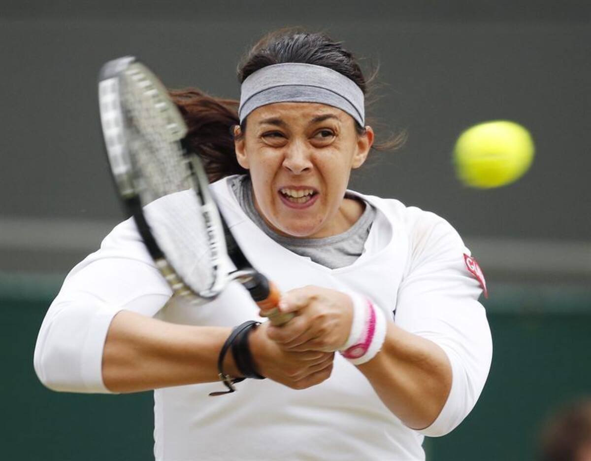 La tenista francesa Marion Bartoli devuelve una bola a la estadounidense Sloane Stephens, durante el partido de cuartos de final del torneo de tenis de Wimbledon.
