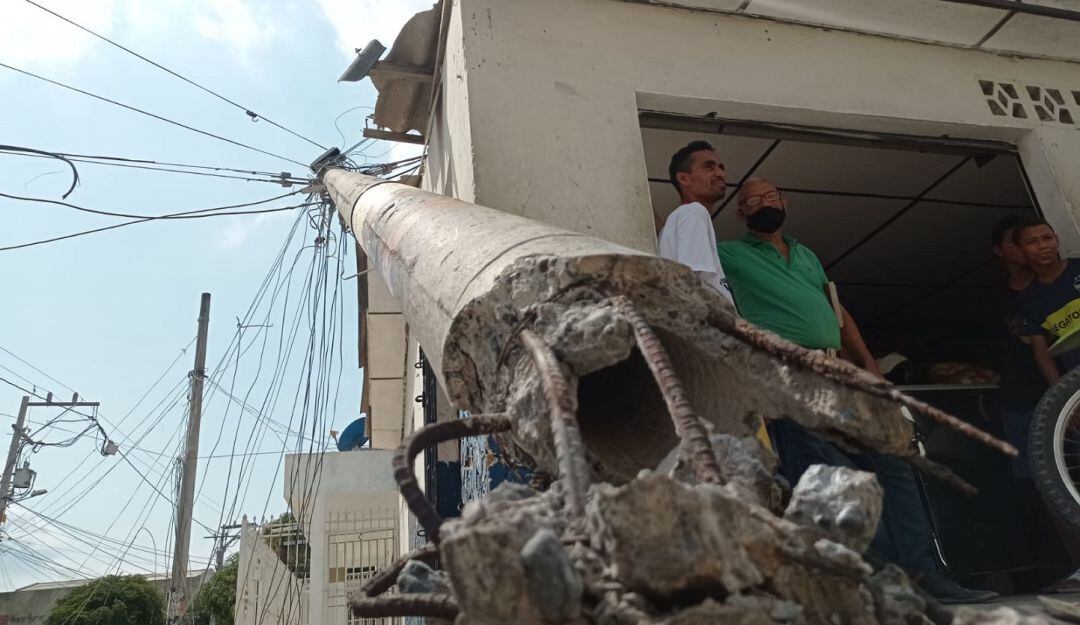 Poste que cayó sobre la fachada de la tienda. 