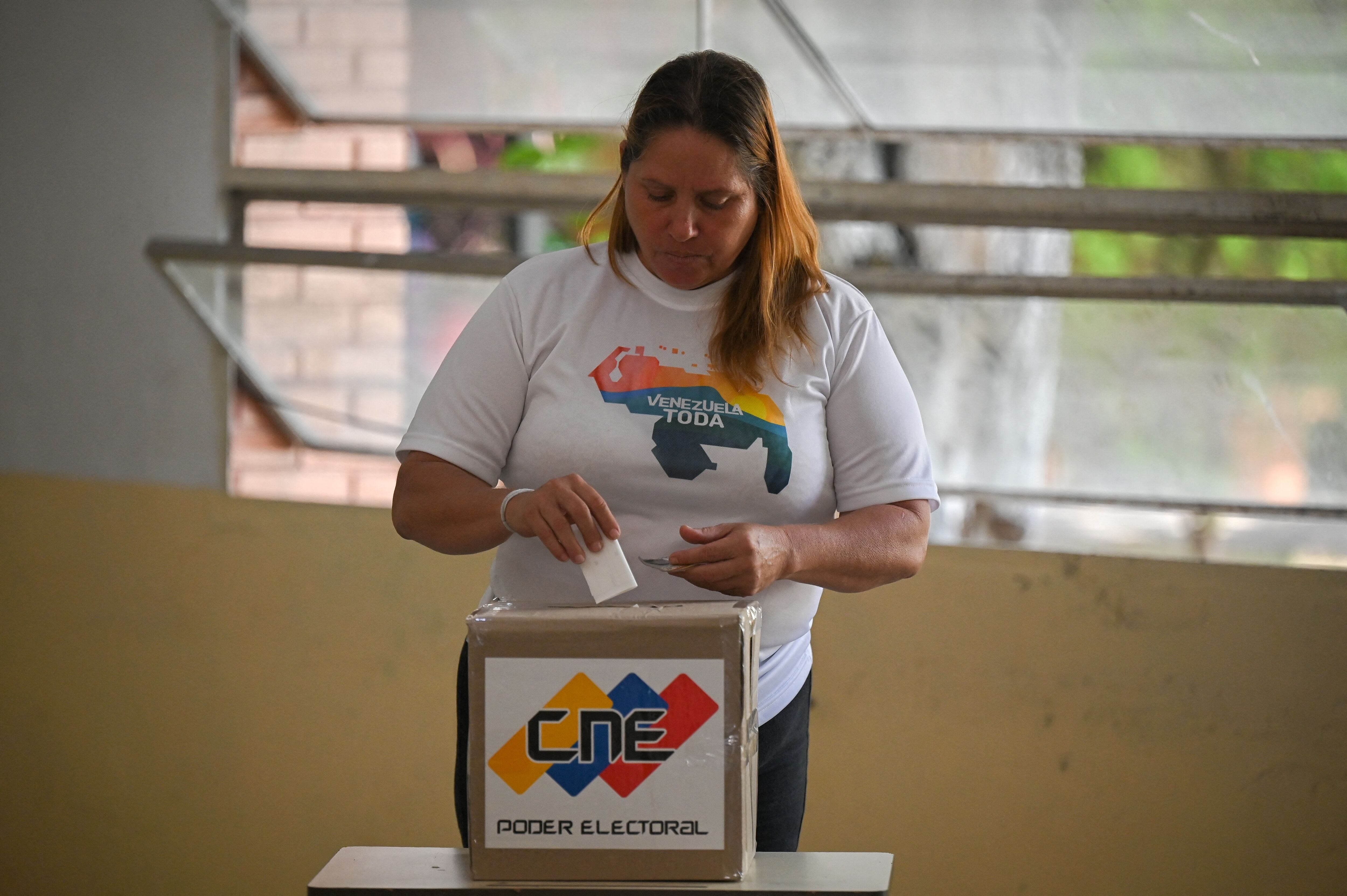 A woman votes at a polling station during a consultative referendum mock on Venezuelan sovereignty over the Esequibo, in Caracas on November 19, 2023. Next December 3 Venezuela will hold a referendum on whether to annex the Esequibo region -a contested oil-rich region administered by Guyana and which makes up more than two-thirds of its territory and home to 125,000 of its 800,000 citizens. The dispute over Esequibo dates back to 1899 when an arbitration tribunal fixed the border between Venezuela and Guyana -- a former colony of both Britain and the Netherlands. (Photo by Federico Parra / AFP) (Photo by FEDERICO PARRA/AFP via Getty Images)