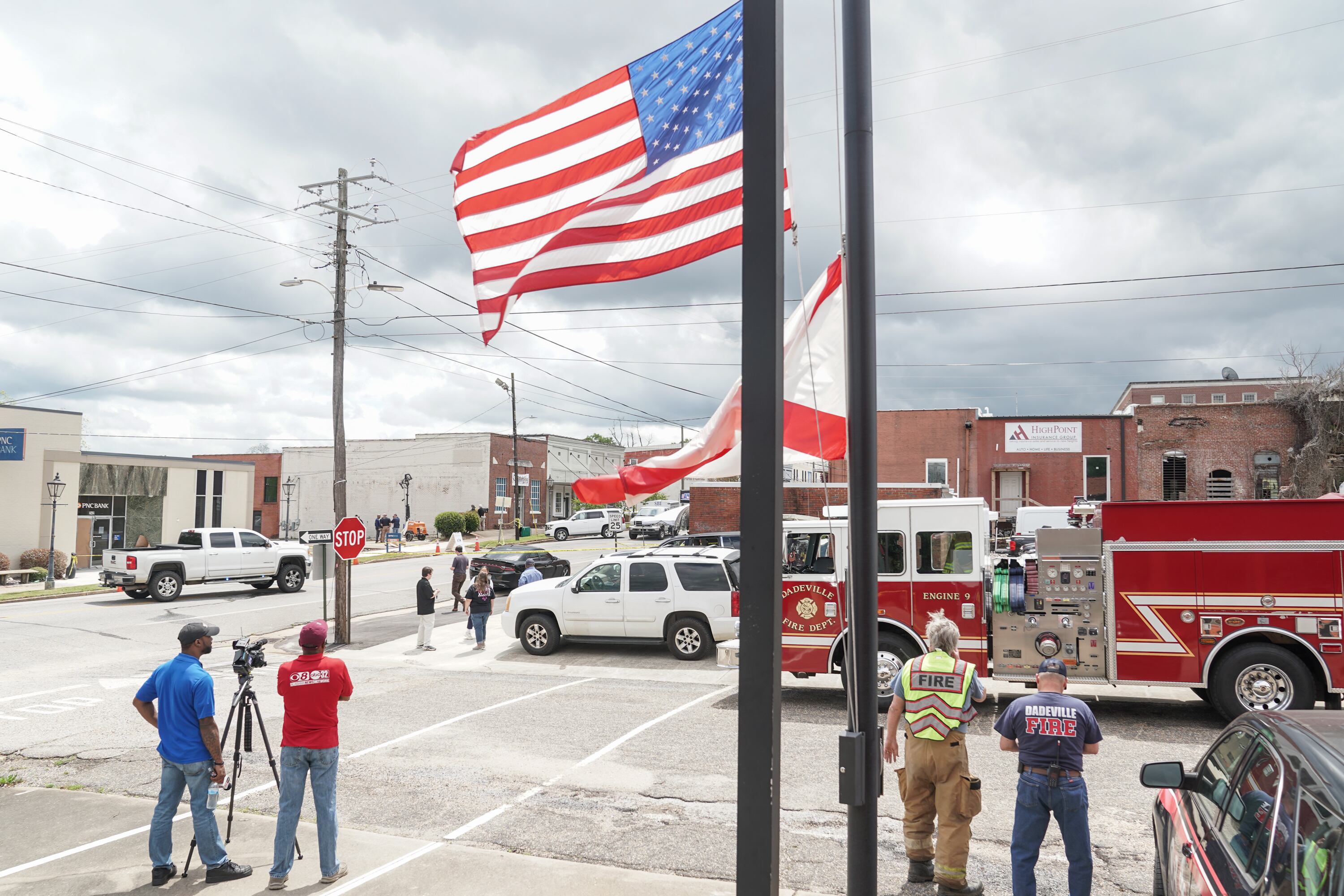 DADEVILLE, AL - APRIL 16: Flags are flown at half-staff while community members watch crime scene investigators work the scene following a shooting at the Mahogany Masterpiece dance studio on April 16, 2023 in Dadeville, Alabama. According to reports, at least four people were killed and others injured in a shooting during a birthday party at the dance studio on Saturday night. (Photo by Megan Varner/Getty Images)