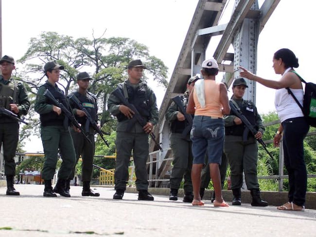 Ciudadanos colombianos hablan con guardias venezolanos en el Puente La Unión buscando pasar la frontera.