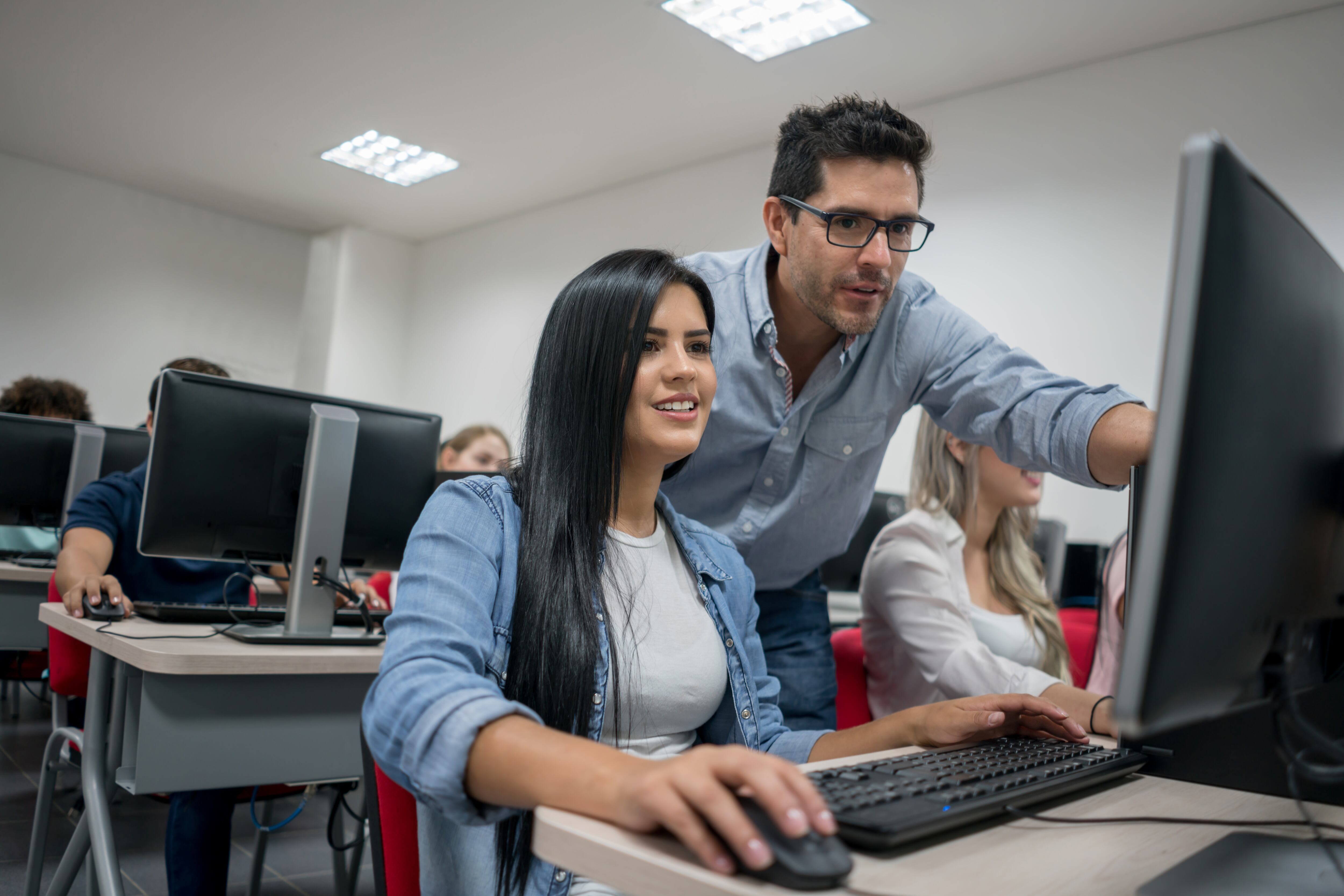 Profesor ayudando a estudiantes en clase / Foto: GettyImages