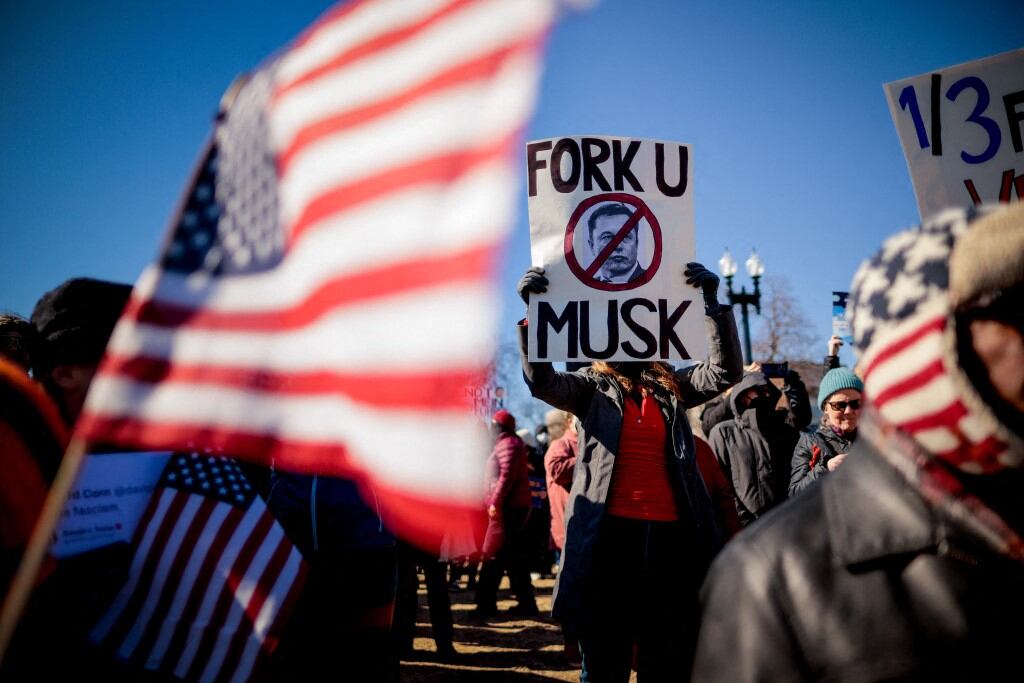 WASHINGTON, DC - FEBRUARY 17: A sign depicting Tesla and SpaceX CEO Elon Musk is visible as protesters rally against the Trump administration during "Not My President's Day" protests at the Capitol Reflecting Pool on February 17, 2025 in Washington, DC. Protests are being held in cities across the nation on Presidents' Day against what the organizers say are "the anti-democratic and illegal actions of the Trump administration." Chip Somodevilla/Getty Images/AFP (Photo by CHIP SOMODEVILLA / GETTY IMAGES NORTH AMERICA / Getty Images via AFP)