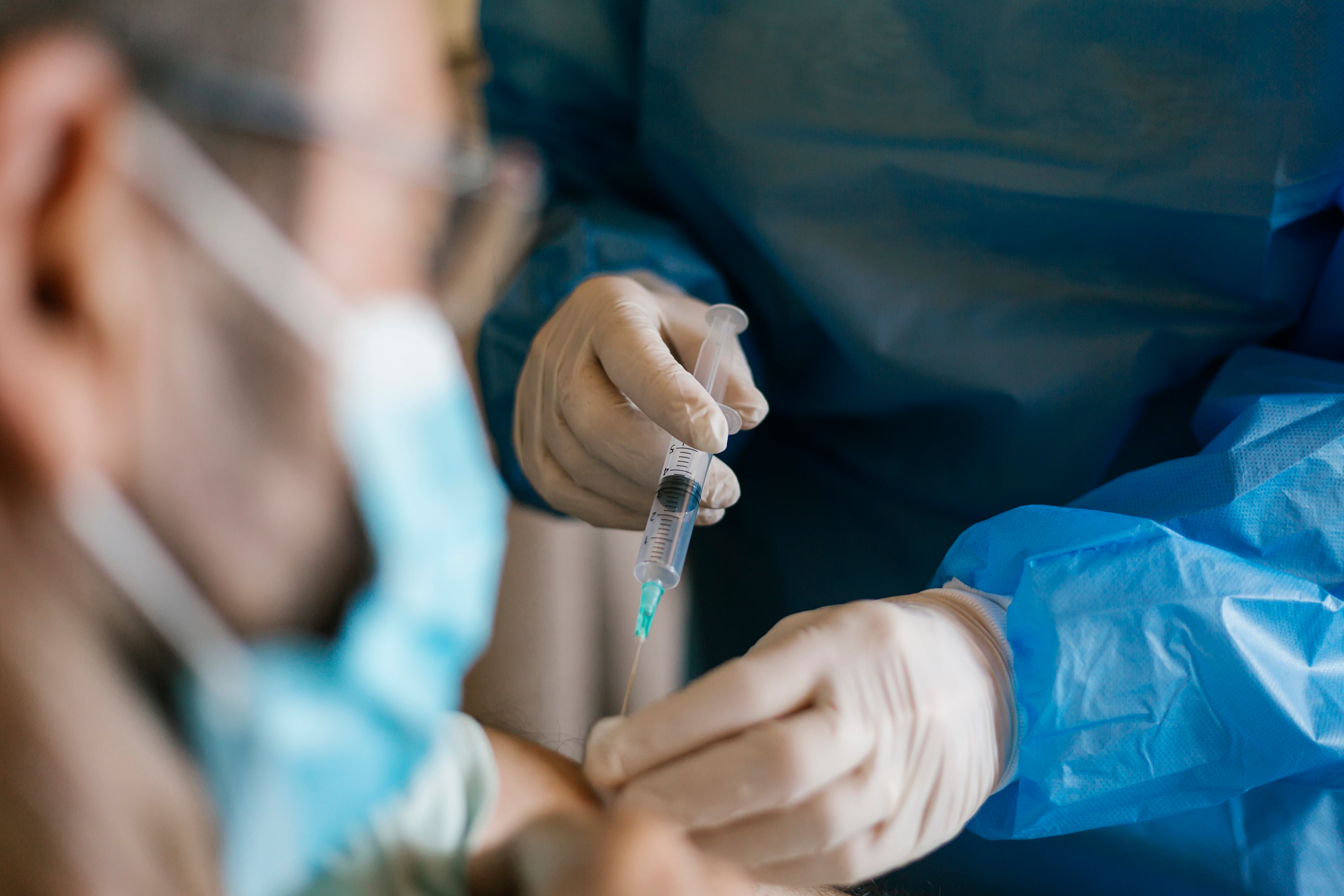 Close-up of a doctor applying the covid-19 vaccine to a senior patient at nursing home during the isolation. Healthcare and medicine concept.