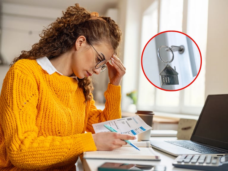 Persona observando un documento de manera preocupada y al lado las llaves de una vivienda (Foto vía Getty Images)