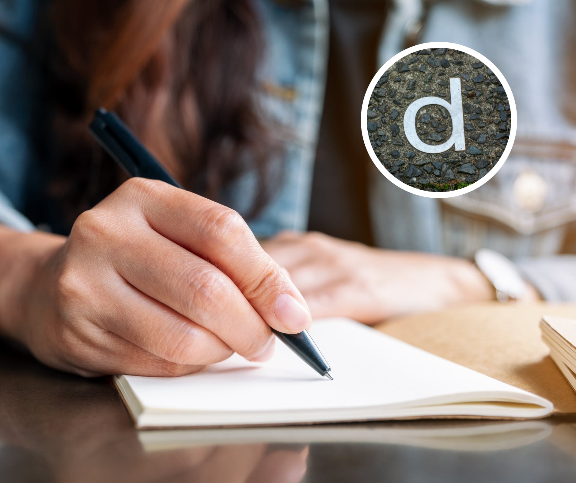 Persona escribiendo algo con un esfero en su cuaderno y la letra ‘D’ a su lado (Getty Images)