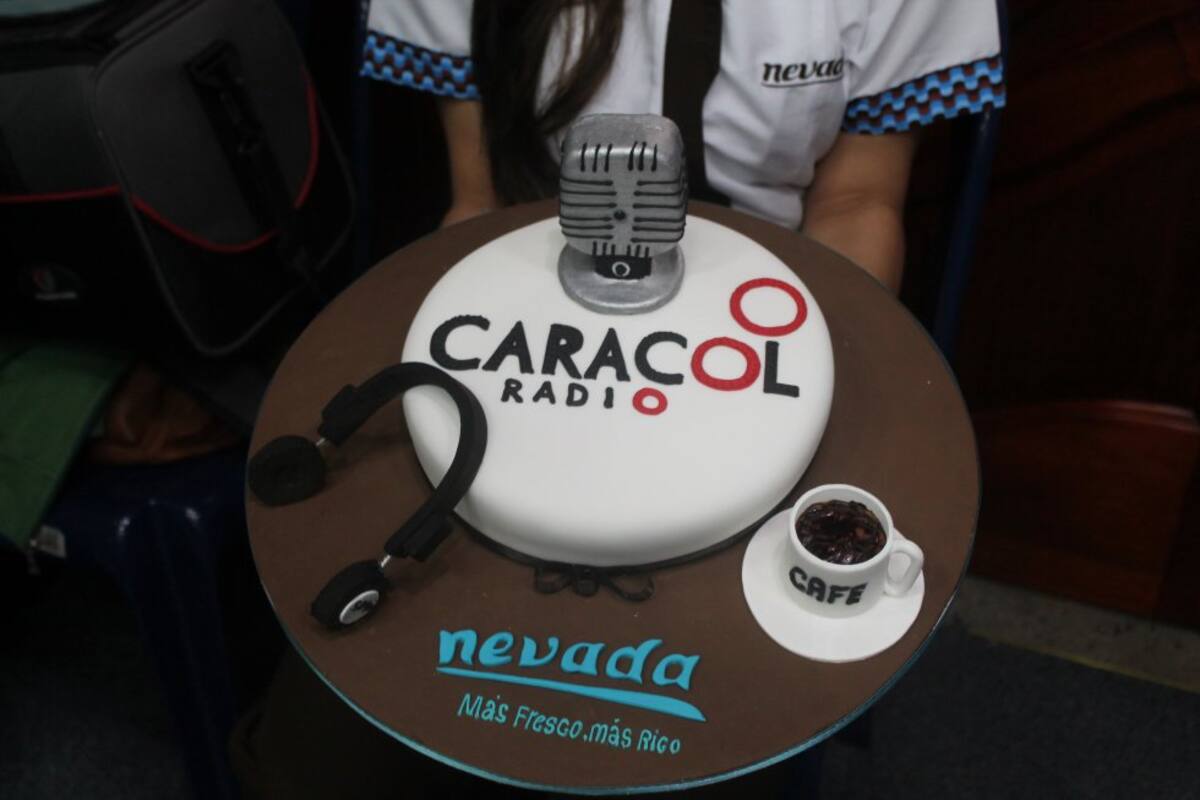 El equipo de 6AM Hoy por Hoy disfrutan de un ponque con decoración de Caracol Radio. 