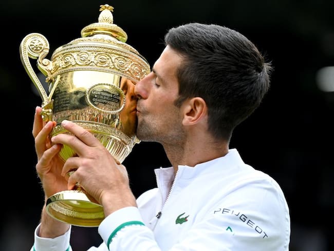 Novak Djokovic besa el trofeo de su sexto título de Wimbledon y el número 20 en Grand Slam.