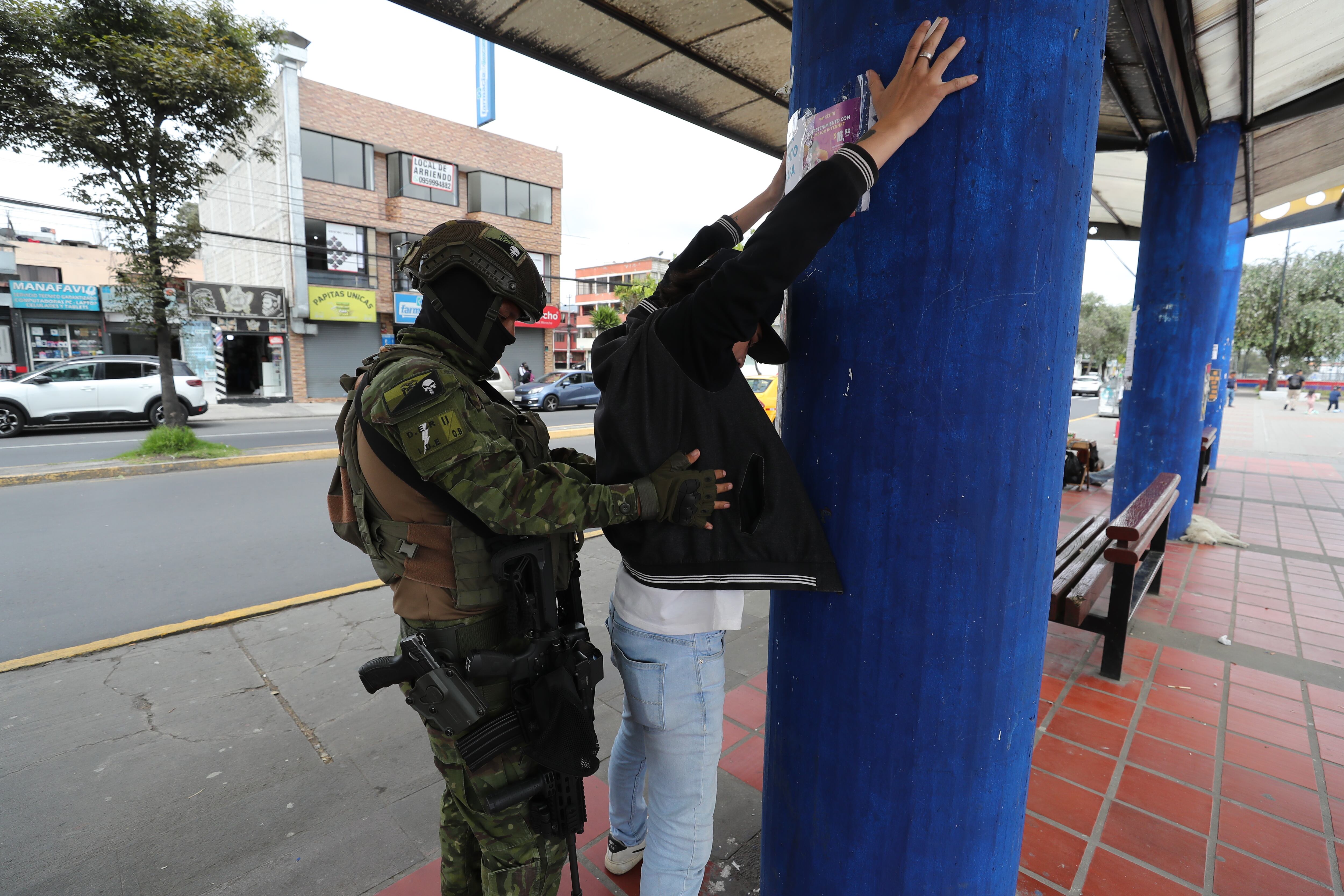 AME8627. QUITO (ECUADOR), 11/01/2024.- Un soldado requisa a un joven hoy, en el sector de Carapungo, en Quito (Ecuador). Ecuador está en medio de un estado de excepción ordenado por el jefe de Estado, quien tras declarar la existencia de un "conflicto armado interno", ordenó a las Fuerzas Armadas ejecutar acciones milites "bajo el derecho internacional humanitario y respetando los derechos humano". EFE/ José Jácome