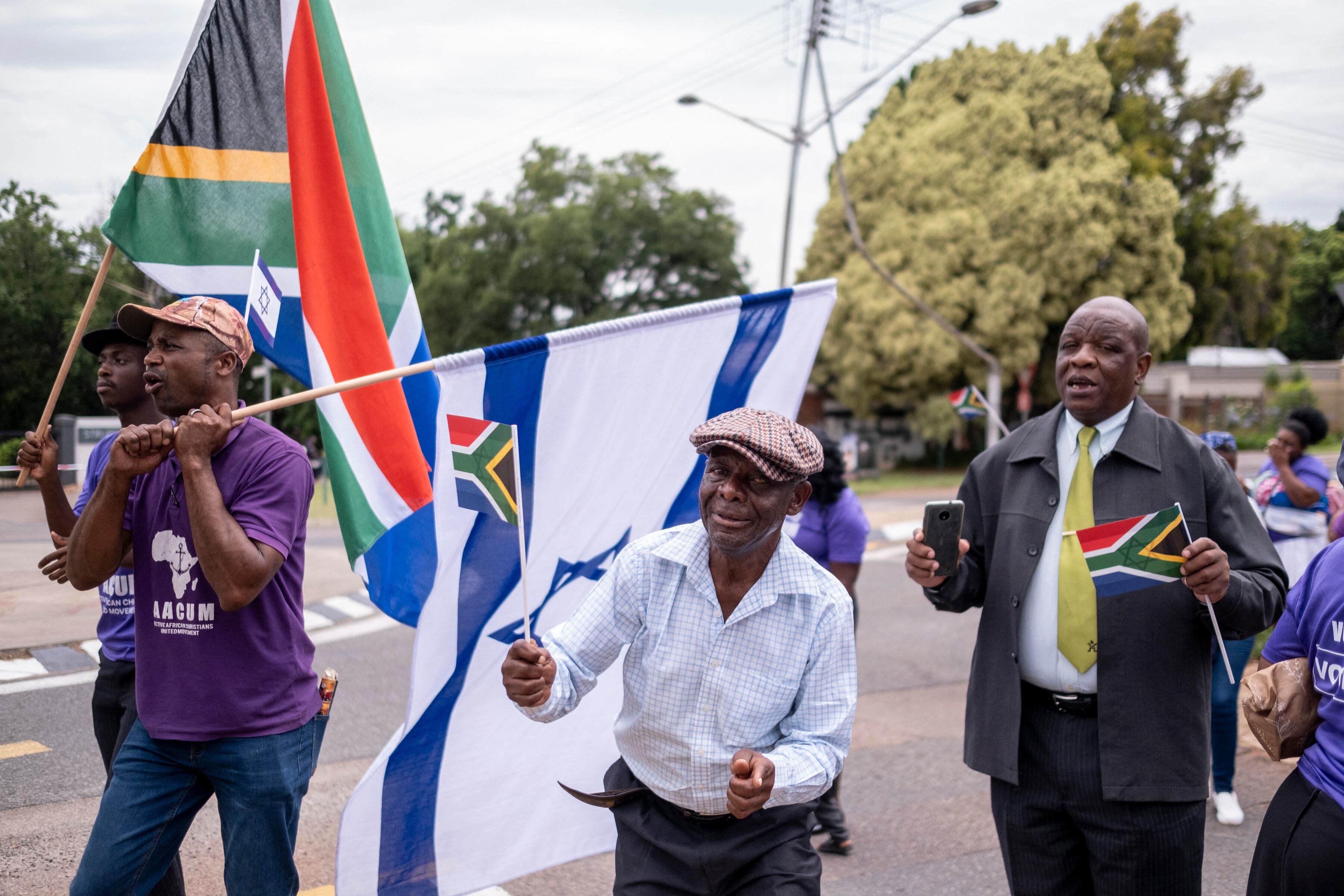 Members of the Active African Christians United Movement (AACUM) sing, dance and wave South African and Israeli flags in support of Israel outside of the embassy of Israel in Pretoria on November 17, 2023. Thousands of civilians, both Palestinians and Israelis, have died since October 7, 2023, after Palestinian Hamas militants based in the Gaza Strip entered southern Israel in an unprecedented attack triggering a war declared by Israel on Hamas with retaliatory bombings on Gaza. (Photo by EMMANUEL CROSET / AFP) (Photo by EMMANUEL CROSET/AFP via Getty Images)