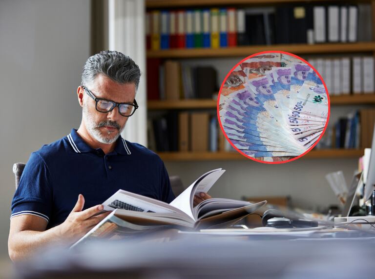 Hombre leyendo un libro en su escritorio de la casa / Dinero colombiano (Getty Images)