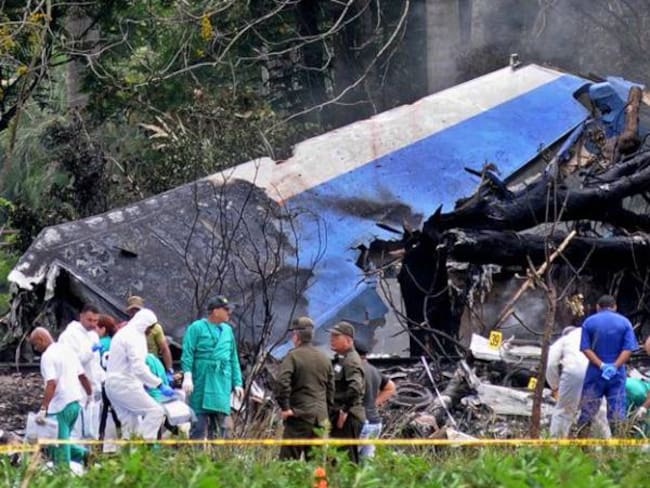 Policías y militares trabajan entre los restos del avión Boeing-737 que se estrelló este viernes.