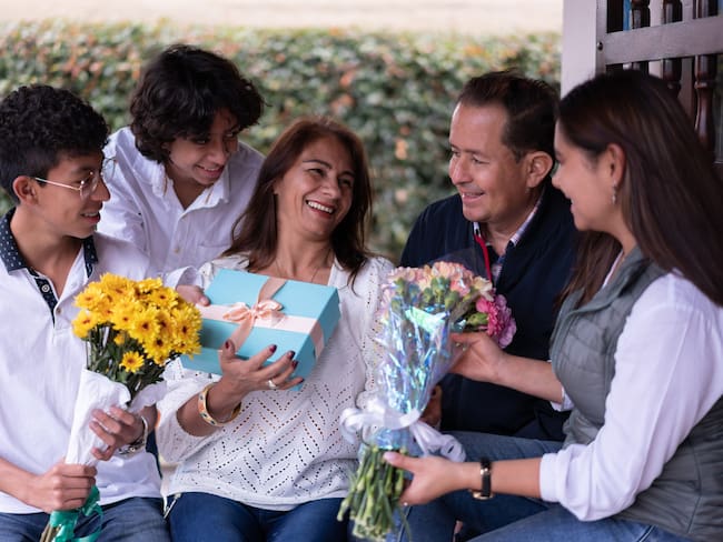 Hijos y esposo celebrando el Día de la Madre 2024, con regalos y flores para el día de la mamá (Getty Images)