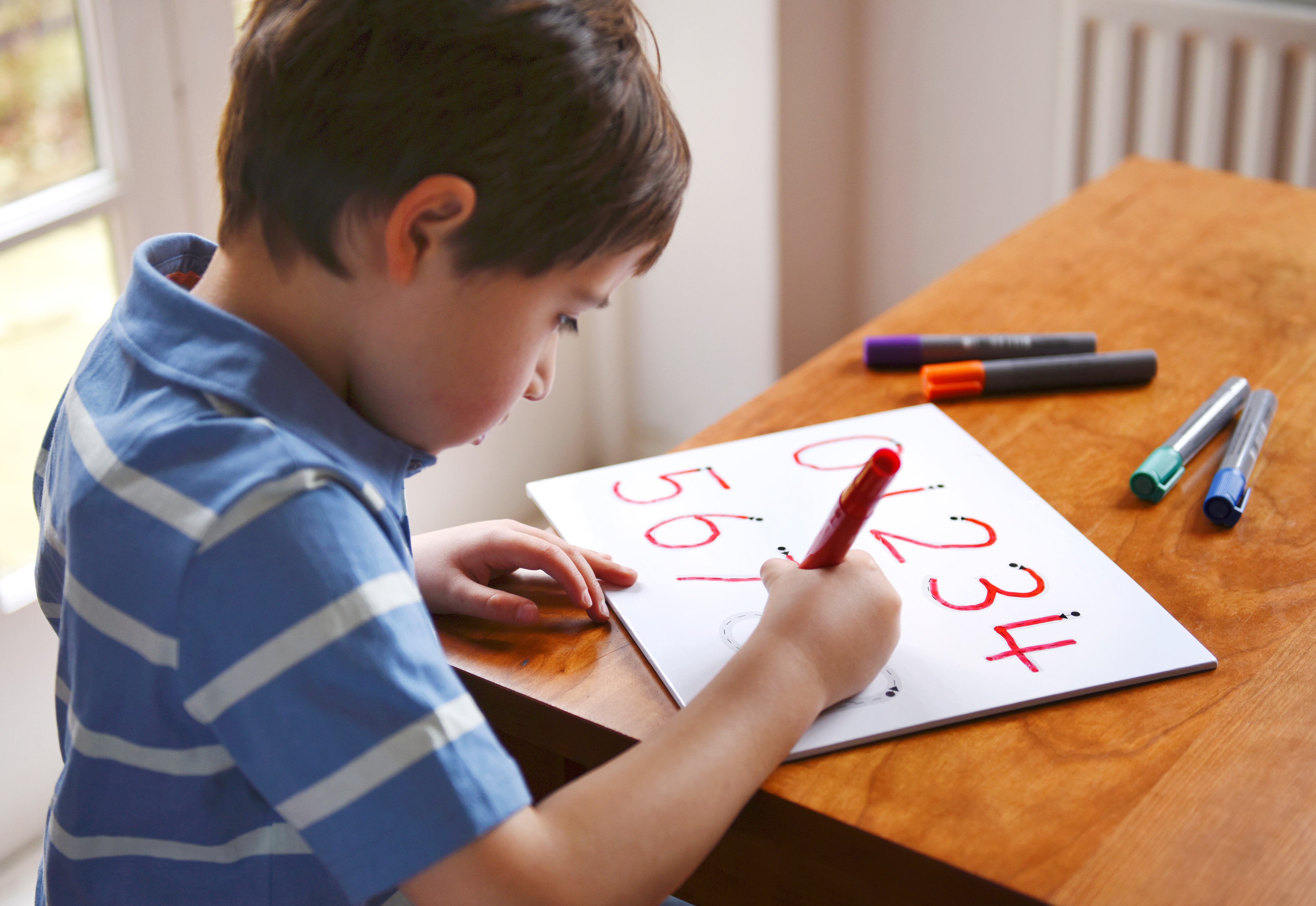Niño escribiendo los números en color rojo. (Foto: Getty Images)