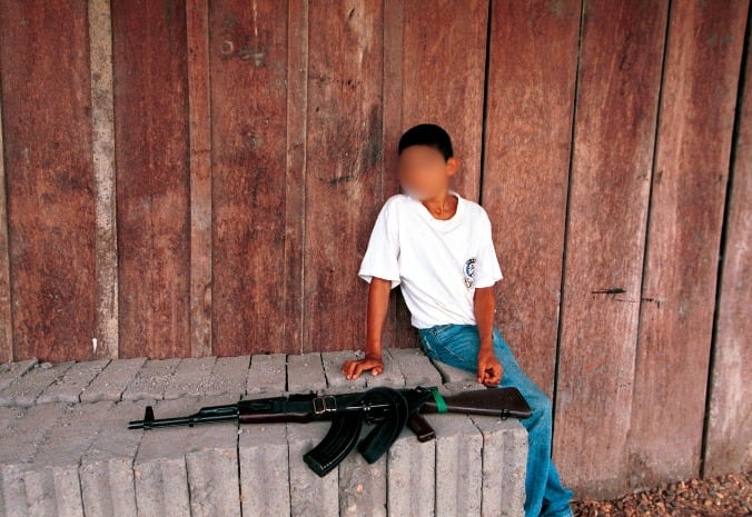 Niño junto a un AK-47 en un "punto de requisa" de las FARC en 2001 en Cristales (Colombia) (Foto: Carlos Villalon/Newsmakers) / Carlos Villalon