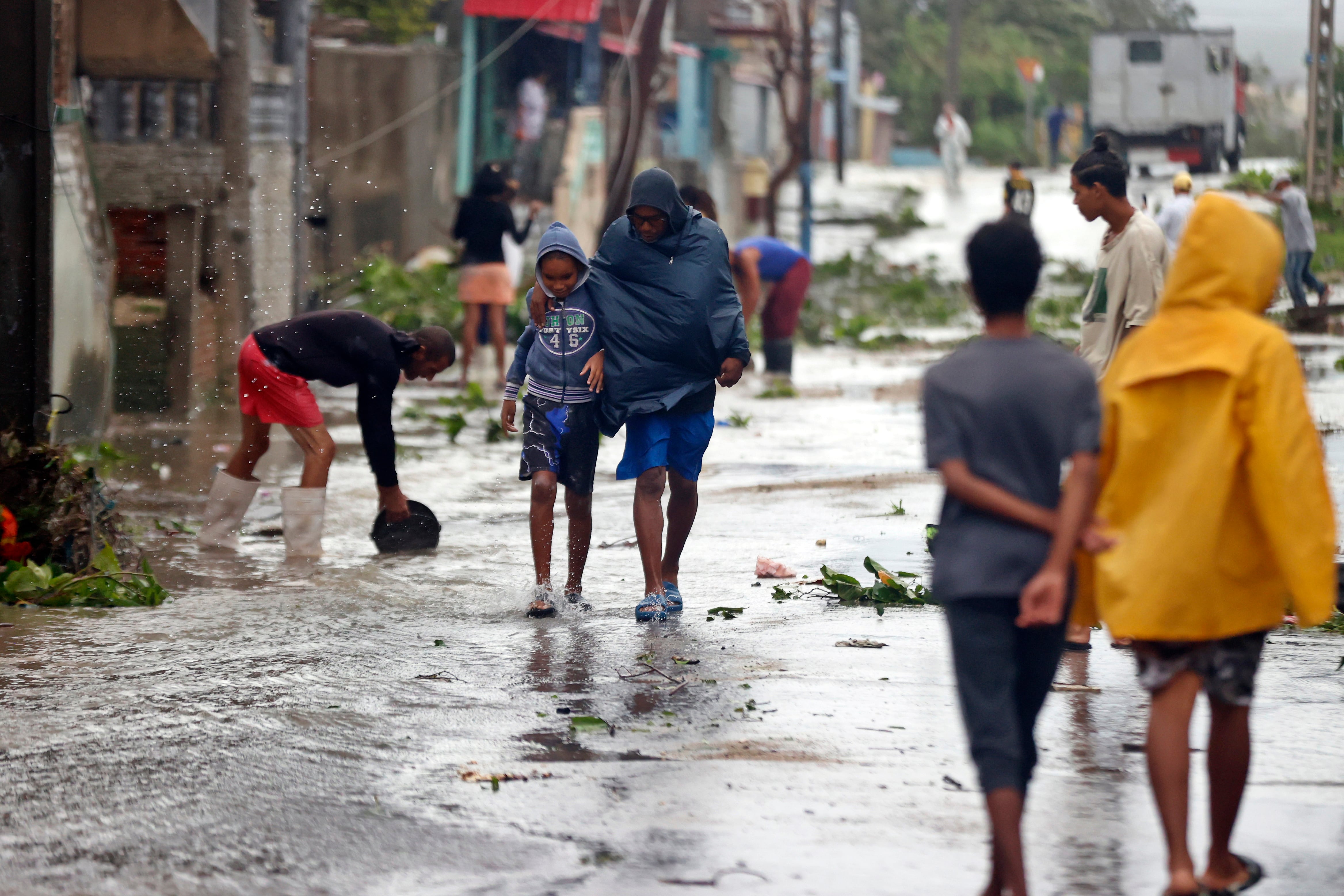Personas caminan por una calle afectada por el paso del huracán Melissa, en Santiago de Cuba (Cuba). 
EFE/ Ernesto Mastrascusa

