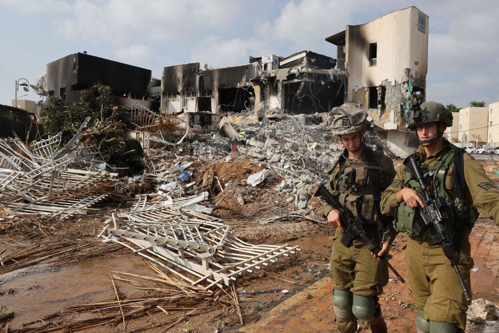 Los soldados caminan frente a una comisaría de policía israelí que resultó dañada durante las batallas para desalojar a los militantes de Hamás que estaban estacionados en su interior (Foto de JACK GUEZ/AFP) (Foto de JACK GUEZ/AFP vía Getty Images)