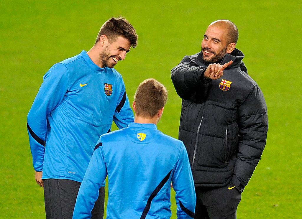 Josep Guardiola y Gerard Pique en el estadio Camp Nou en diciembre de 2011 (Photo credit should read LLUIS GENE/AFP via Getty Images)
